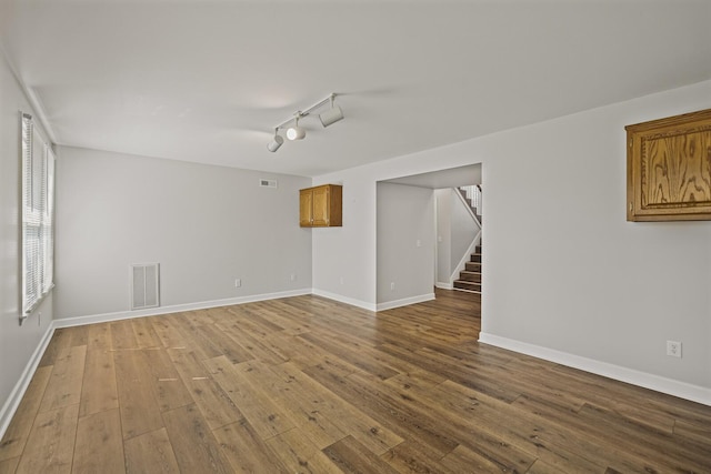 spare room with wood-type flooring and rail lighting