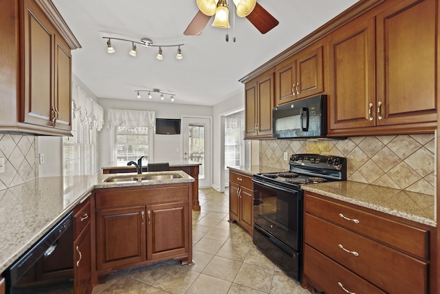 kitchen featuring black appliances, backsplash, sink, and light stone counters