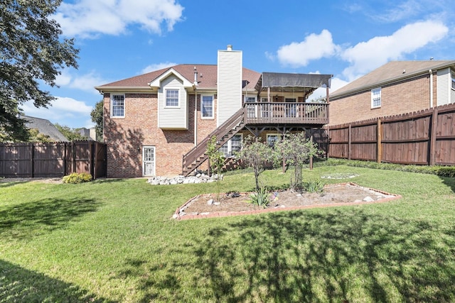 rear view of property with a yard and a wooden deck