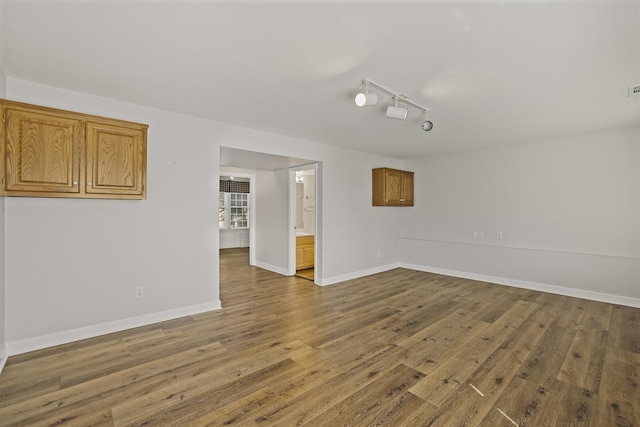 empty room featuring rail lighting and hardwood / wood-style floors