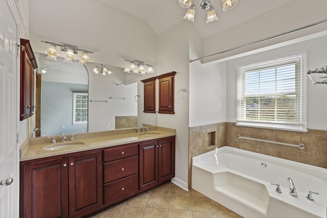 bathroom with ceiling fan, tile patterned floors, a tub, vaulted ceiling, and vanity