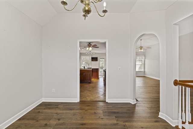 interior space featuring dark hardwood / wood-style flooring, lofted ceiling, and ceiling fan with notable chandelier