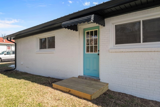 view of exterior entry with a lawn