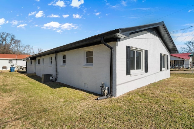 view of home's exterior with a yard and central AC unit