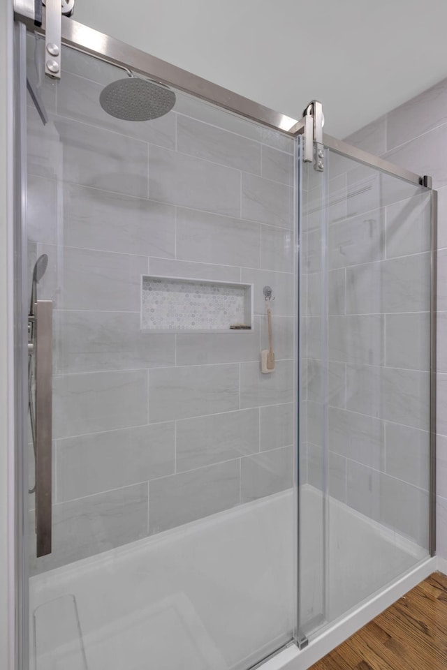 bathroom featuring a shower with shower door and hardwood / wood-style floors