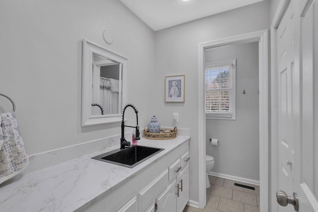 bathroom with toilet, tile patterned flooring, and vanity