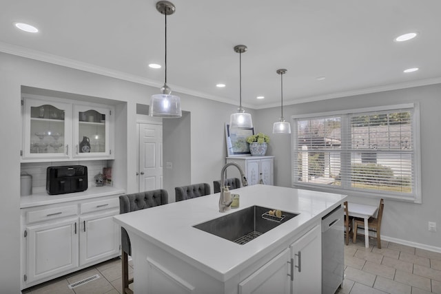 kitchen featuring light tile patterned floors, an island with sink, stainless steel dishwasher, white cabinets, and sink