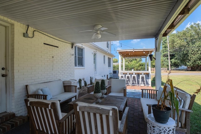 view of patio with ceiling fan, an outdoor living space, and an outdoor bar