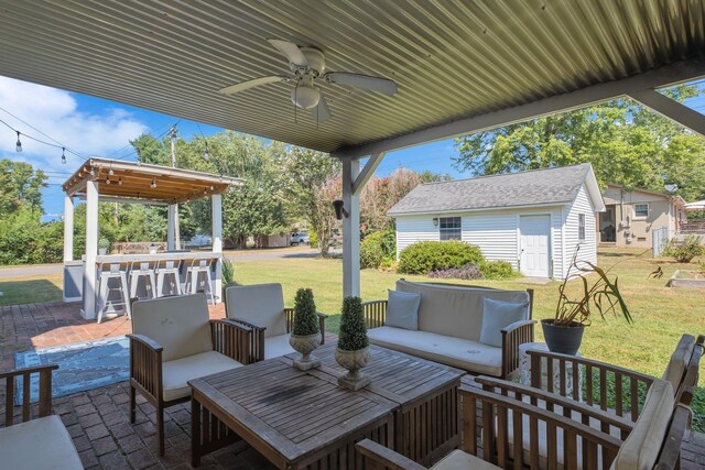 view of patio / terrace with ceiling fan, an outbuilding, a bar, and an outdoor hangout area