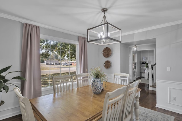 dining space featuring dark hardwood / wood-style flooring, crown molding, and an inviting chandelier