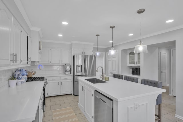 kitchen featuring a breakfast bar, white cabinetry, appliances with stainless steel finishes, and a center island with sink