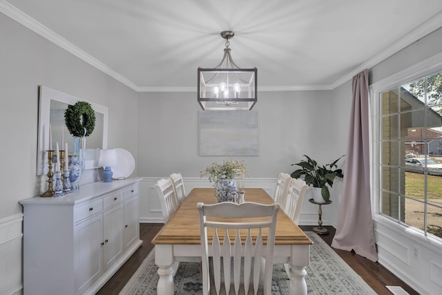 dining space featuring dark wood-type flooring, a chandelier, and ornamental molding