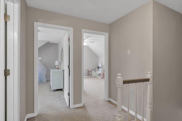 corridor with light colored carpet and vaulted ceiling