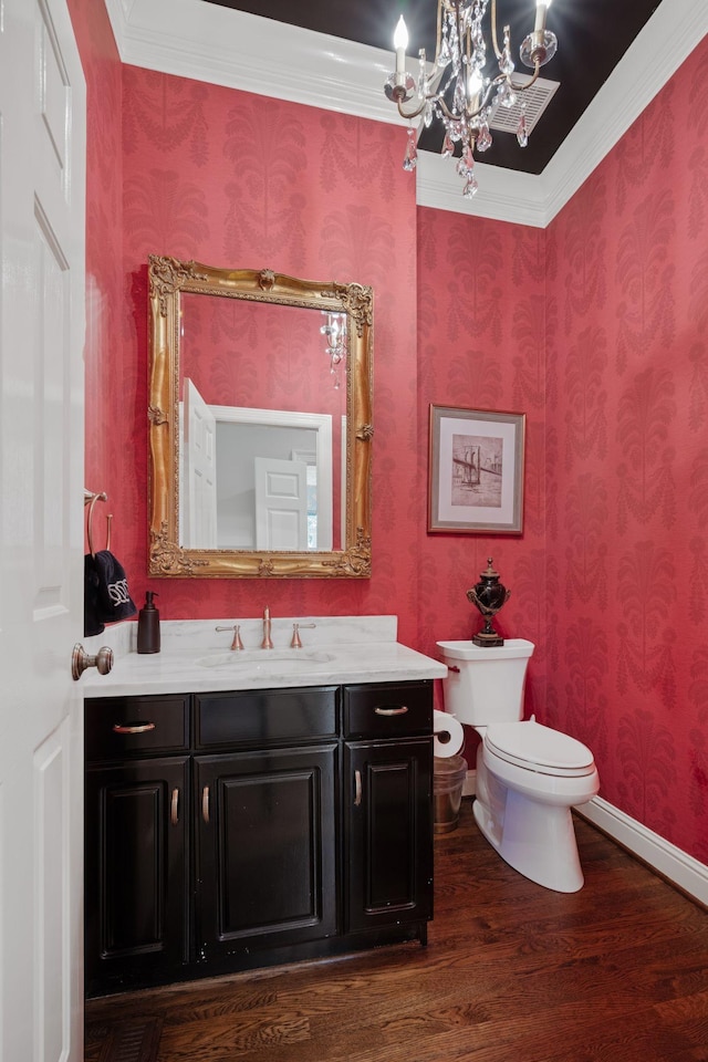 bathroom with toilet, hardwood / wood-style flooring, a chandelier, crown molding, and vanity