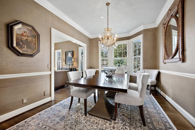 dining space featuring dark hardwood / wood-style flooring, an inviting chandelier, and ornamental molding