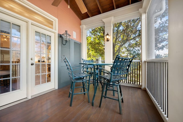 sunroom / solarium featuring ceiling fan, wooden ceiling, plenty of natural light, and vaulted ceiling with beams