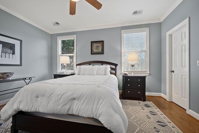 bedroom featuring ceiling fan, wood-type flooring, and ornamental molding