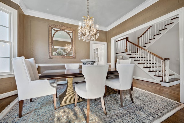 dining area with ornamental molding, hardwood / wood-style floors, and a notable chandelier