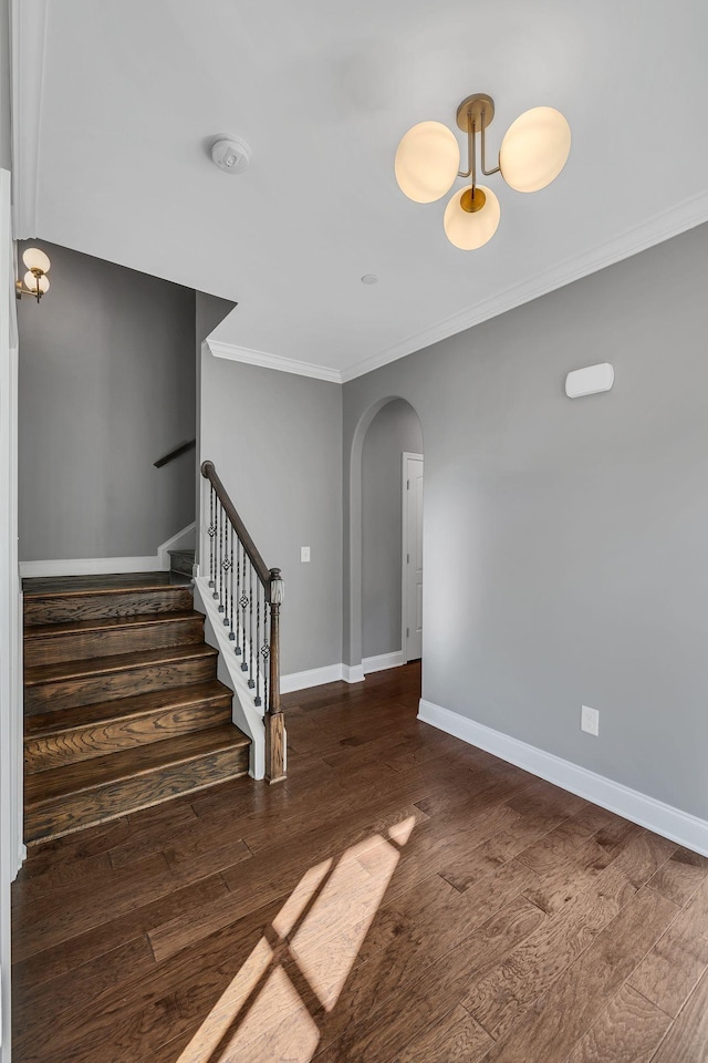 stairs with ornamental molding and hardwood / wood-style floors