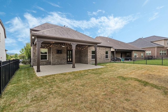 back of property with a patio area and a yard