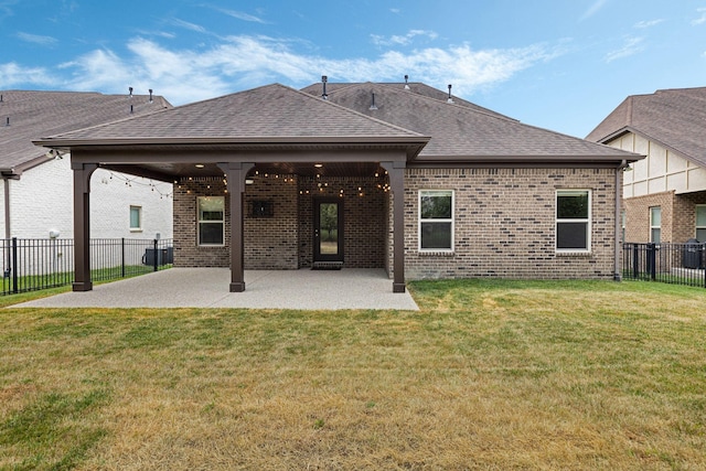 back of house featuring a patio area and a yard