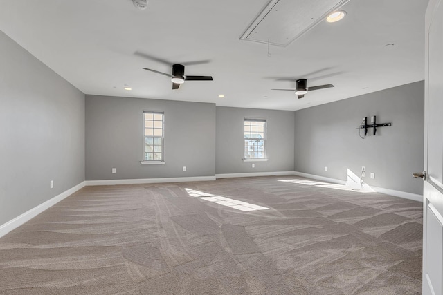 unfurnished room featuring ceiling fan, light colored carpet, and a healthy amount of sunlight