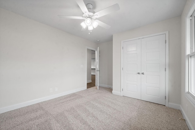 unfurnished bedroom featuring ceiling fan, a closet, and carpet flooring