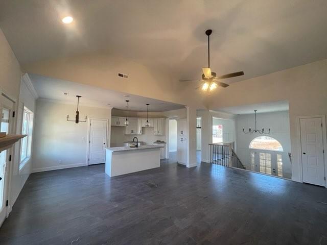 kitchen with white cabinetry, an island with sink, ceiling fan, dark hardwood / wood-style floors, and pendant lighting