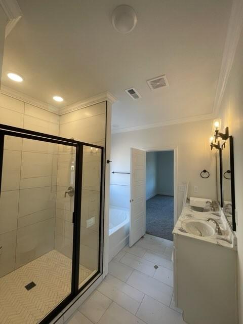 bathroom featuring ornamental molding, separate shower and tub, and vanity