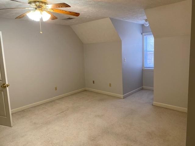 bonus room featuring ceiling fan, light colored carpet, a textured ceiling, and vaulted ceiling