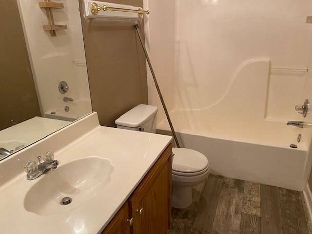 full bathroom with hardwood / wood-style floors, toilet, vanity, and  shower combination