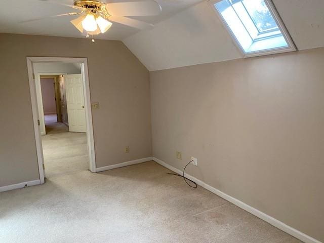 bonus room with ceiling fan, vaulted ceiling with skylight, and light colored carpet