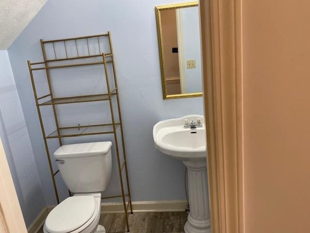 bathroom featuring a textured ceiling, toilet, and hardwood / wood-style floors