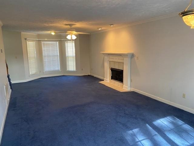 unfurnished living room featuring ceiling fan, a textured ceiling, a tile fireplace, and ornamental molding