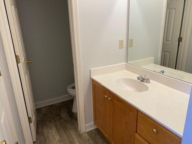 bathroom featuring hardwood / wood-style flooring, toilet, and vanity