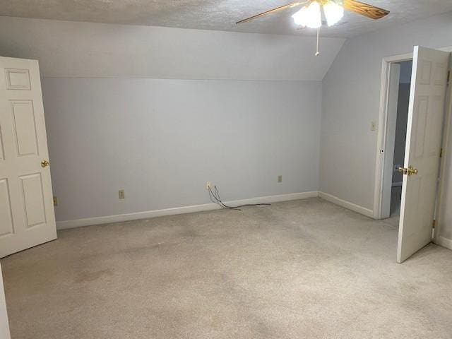 bonus room with lofted ceiling, light colored carpet, ceiling fan, and a textured ceiling