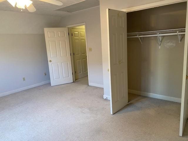 unfurnished bedroom featuring vaulted ceiling, ceiling fan, a closet, and light colored carpet