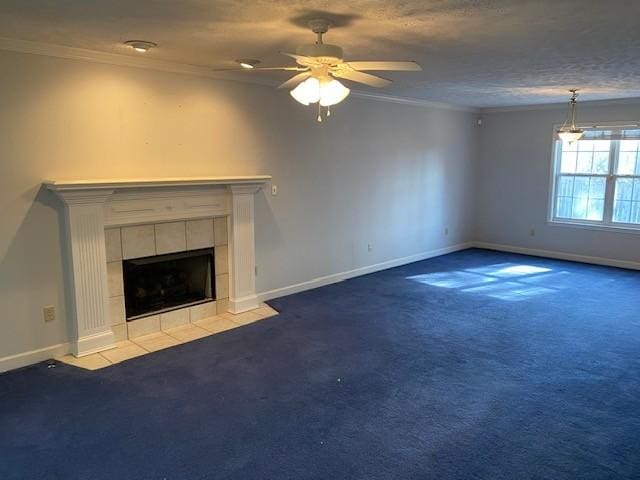 unfurnished living room with carpet, ceiling fan, a tile fireplace, and ornamental molding