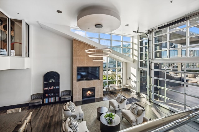 living room with expansive windows, a tile fireplace, and hardwood / wood-style flooring