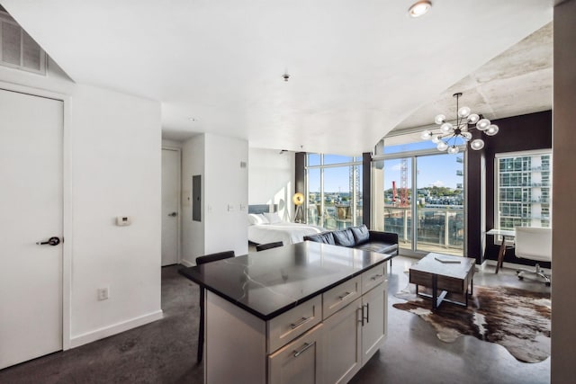 kitchen featuring a kitchen island, a wall of windows, decorative light fixtures, and a notable chandelier