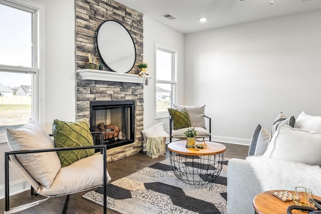 sitting room featuring ceiling fan, dark hardwood / wood-style flooring, a fireplace, and plenty of natural light