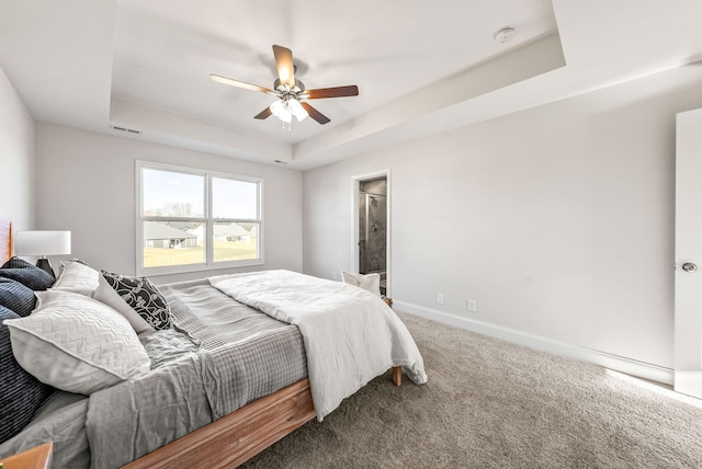 carpeted bedroom with ceiling fan and a tray ceiling