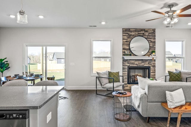 living room with ceiling fan, dark hardwood / wood-style floors, and a fireplace