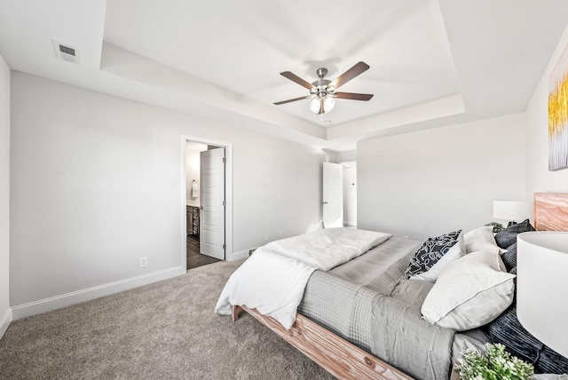 carpeted bedroom featuring ceiling fan, connected bathroom, and a raised ceiling