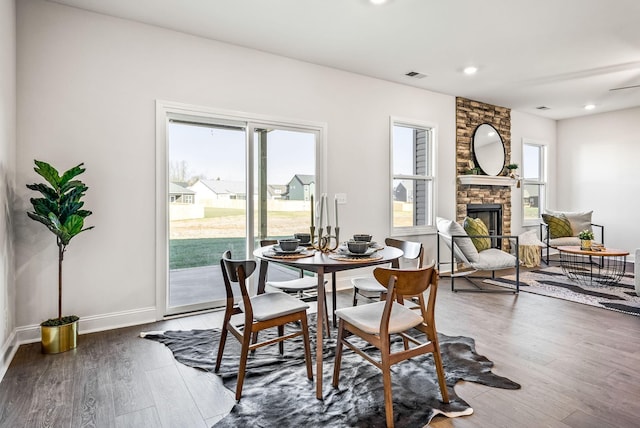 dining room with dark hardwood / wood-style floors and a fireplace