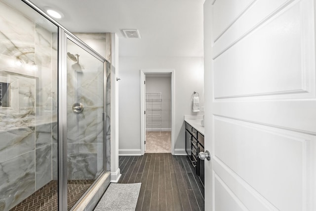 bathroom with a shower with shower door and vanity