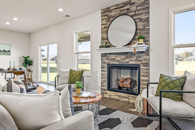 living room with dark hardwood / wood-style floors, a healthy amount of sunlight, and a fireplace