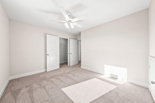 unfurnished bedroom featuring ceiling fan, a closet, and light carpet