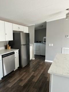 kitchen with dark hardwood / wood-style floors, separate washer and dryer, appliances with stainless steel finishes, and white cabinetry