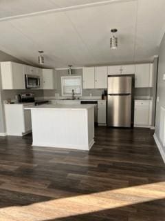 kitchen with white cabinets, appliances with stainless steel finishes, and dark hardwood / wood-style flooring